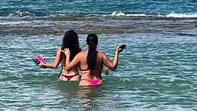 two pretty latinas kiss big asses on public beach