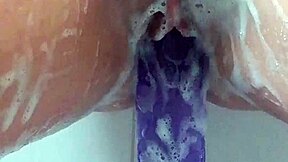 milf soaks in bath thrusting big purple 12-inch dildo till she cums hard