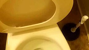 21-year-old stands over toilet pissing while penis slightly peeks out