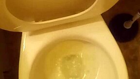21-year-old stands over toilet pissing while penis slightly peeks out