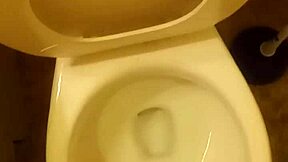 21-year-old stands over toilet pissing while penis slightly peeks out