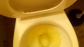 21-year-old stands over toilet pissing while penis slightly peeks out