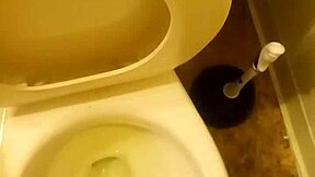 21-year-old stands over toilet pissing while penis slightly peeks out