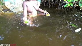 Thick african woman teases naked by the river