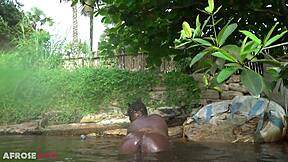 Thick african woman teases naked by the river