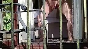 naughty girl enjoys wanking in full view on the balcony