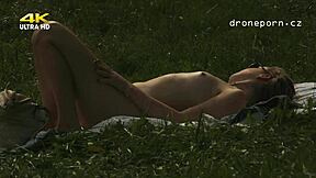 Young girl with small 18+ tits masturbating on the grass