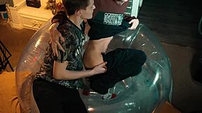 two sweet guys share an inflatable chair for fun