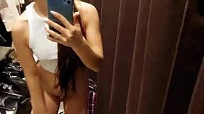 A tanned petite girl next door risks public masturbation in fitting room for orgasm