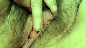 Mature MILF wife warms up her hairy pussy with close-up solo fingering in homemade video.