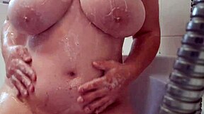 Busty teen washes and massages soapy breasts.