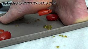 This mature housewife enjoys trampling tomatoes with her bare feet in a fun kitchen activity
