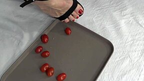 This mature housewife enjoys trampling tomatoes with her bare feet in a fun kitchen activity