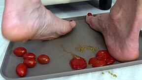 This mature housewife enjoys trampling tomatoes with her bare feet in a fun kitchen activity