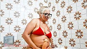 She inserts dildo in pussy and pisses in bathroom.