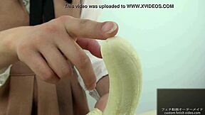 Chica asiática aplasta plátano en fetichismo de mano