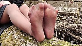 Goddess in spring forest teases you with feet in tan pantyhose.