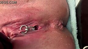 German milf rubs her pierced clit in latex gloves, releasing a hard pee stream