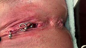 German milf rubs her pierced clit in latex gloves, releasing a hard pee stream