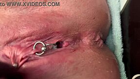 German milf rubs her pierced clit in latex gloves, releasing a hard pee stream