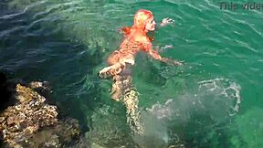 Blue water surrounds the naked girl in this public exhibition