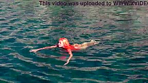 Blue water surrounds the naked girl in this public exhibition