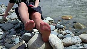 goddess in tan nylons show her cute nylon soles and toes on the riverside