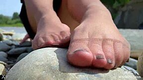 goddess in tan nylons show her cute nylon soles and toes on the riverside