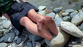 goddess in tan nylons show her cute nylon soles and toes on the riverside