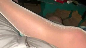 Her shiny pantyhose legs gleam through see-through fabric so enticingly