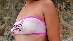 pretty brunette babe flashes bikini teasing beach crowds outdoors