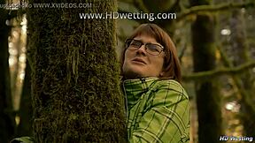 bound and handcuffed to forest tree she squirms desperate for pee release in nature accident