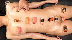 Japanese sushi girl poses playfully with food on her smooth shaved body.