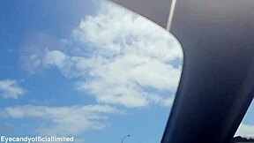 Naughty brunette flashes natural tits pussy from sports car top down