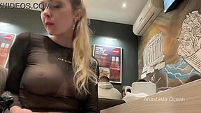 Exhibiendo mis tetas grandes en blusa transparente en café público.