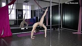 Русская черноволосая гимнастка показывает любительские движения на диване во время тренировки